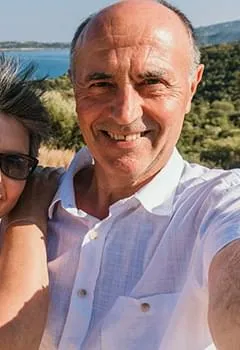 Close-up outdoor portrait of a smiling middle-aged man, illustrating health transformation and confidence.